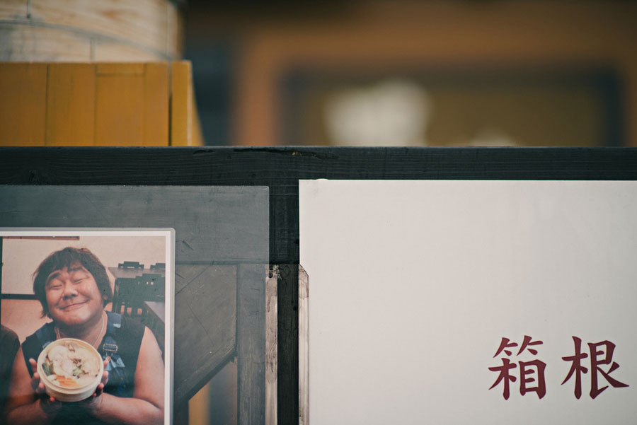 Photo of a man holding a bowl and Japanese kanji text for Hakone on a shopfront display
